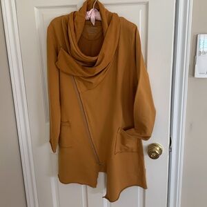 Comfortable casual zip closure with wrap collar and asymmetrical hem.